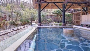 A stone pool with a wooden deck and a thatched roof structure. - Itamuro Onsen Okunasu Taishomura Sachinoyu Onsen (Nasushiobara)