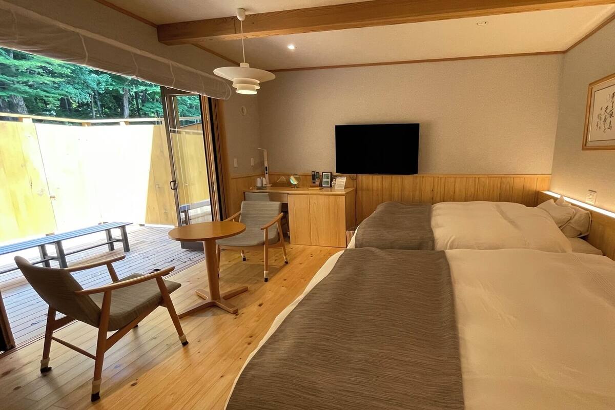 A room with a bed, a desk, a chair, and a TV.