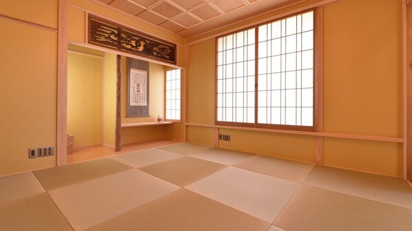 Una habitación japonesa tradicional con suelo de tatami, puertas correderas y un celosía de papel.