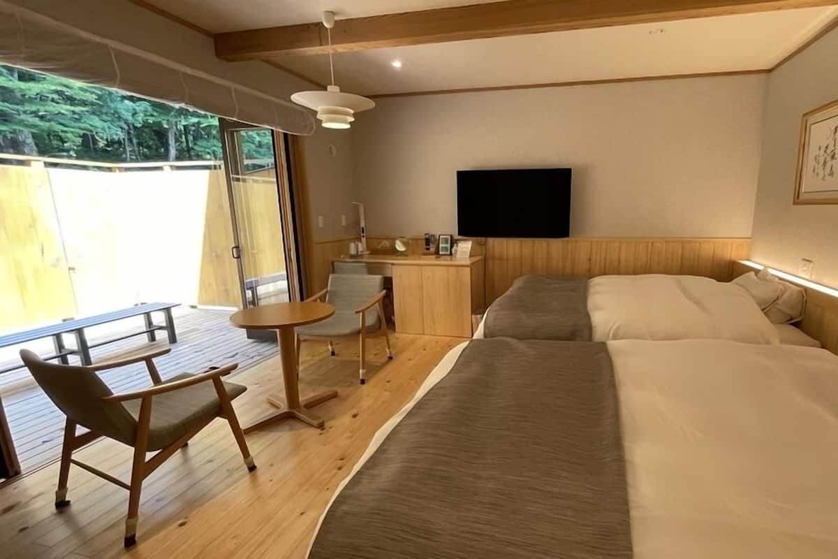 A room with a bed, a desk, a chair, and a TV.