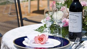 A table set outdoors with a bottle of wine, a rose, and glassware. - Sakuto Valentine Hotel (Mimasaka)