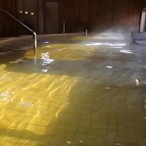 A pool with a tiled floor and a water feature. - Hotel Monzen No Yu (Joetsu)