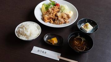 A meal with rice, a bowl of soup, and a small dish of pickled vegetables on a table.