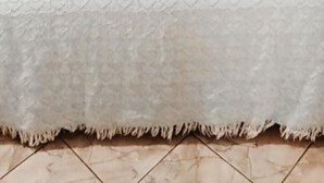 A bed with a wooden headboard, patterned bedding, and a decorative swan centerpiece. - Pousada e Hostel Chapada Suítes (Lençóis)