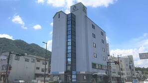 A multi-story building with a prominent entrance and signage indicating it is a hotel. - Hotel Alpha Ayabe (Ayabe)