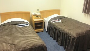 A hotel room with two single beds, a bedside table with a phone, and a small shelf. - Hotel Alpha Ayabe (Ayabe)