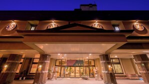 A hotel entrance with a traditional architectural style, featuring a large overhang and stone pillars. - Asamushi Onsen Nanbuya Kaisenkaku (Aomori)