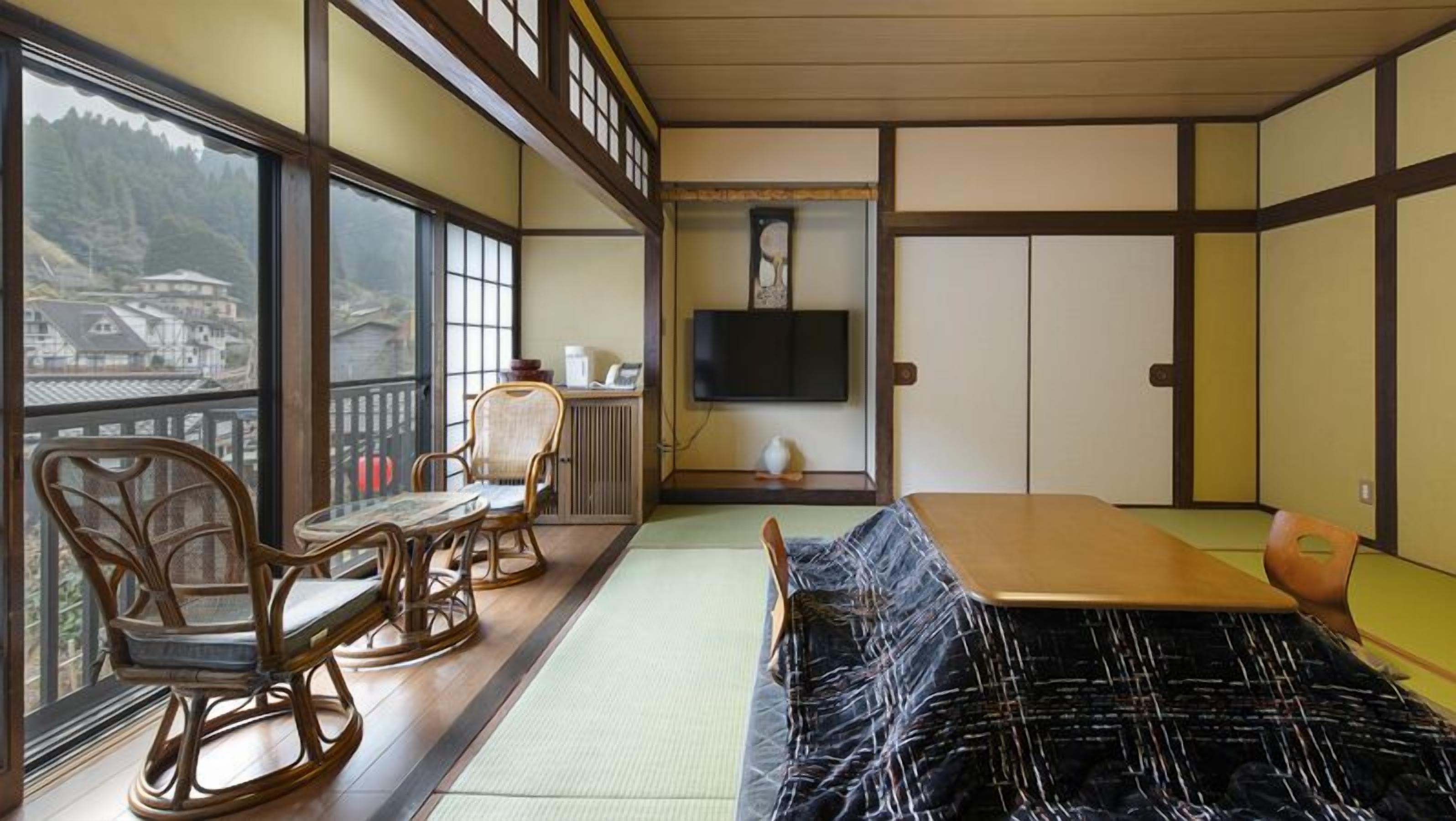 Ein traditioneller japanischer Raum mit Tatami-Böden, einem niedrigen Tisch und einer Couch.