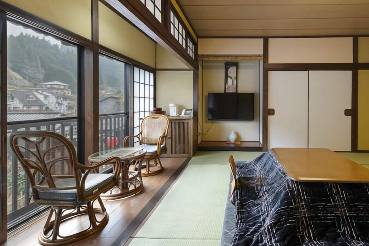 A traditional Japanese room with tatami flooring, a low table, and a sofa.