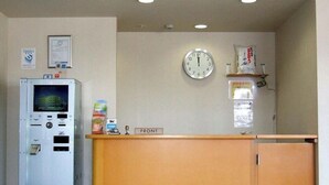 A reception area with a clock, a vending machine, and a sign labeled "FRONT". - Hotel Joetsu Public City (Joetsu)