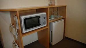A compact kitchenette with a microwave, a small refrigerator, and a glass cabinet. - Hotel Joetsu Public City (Joetsu)