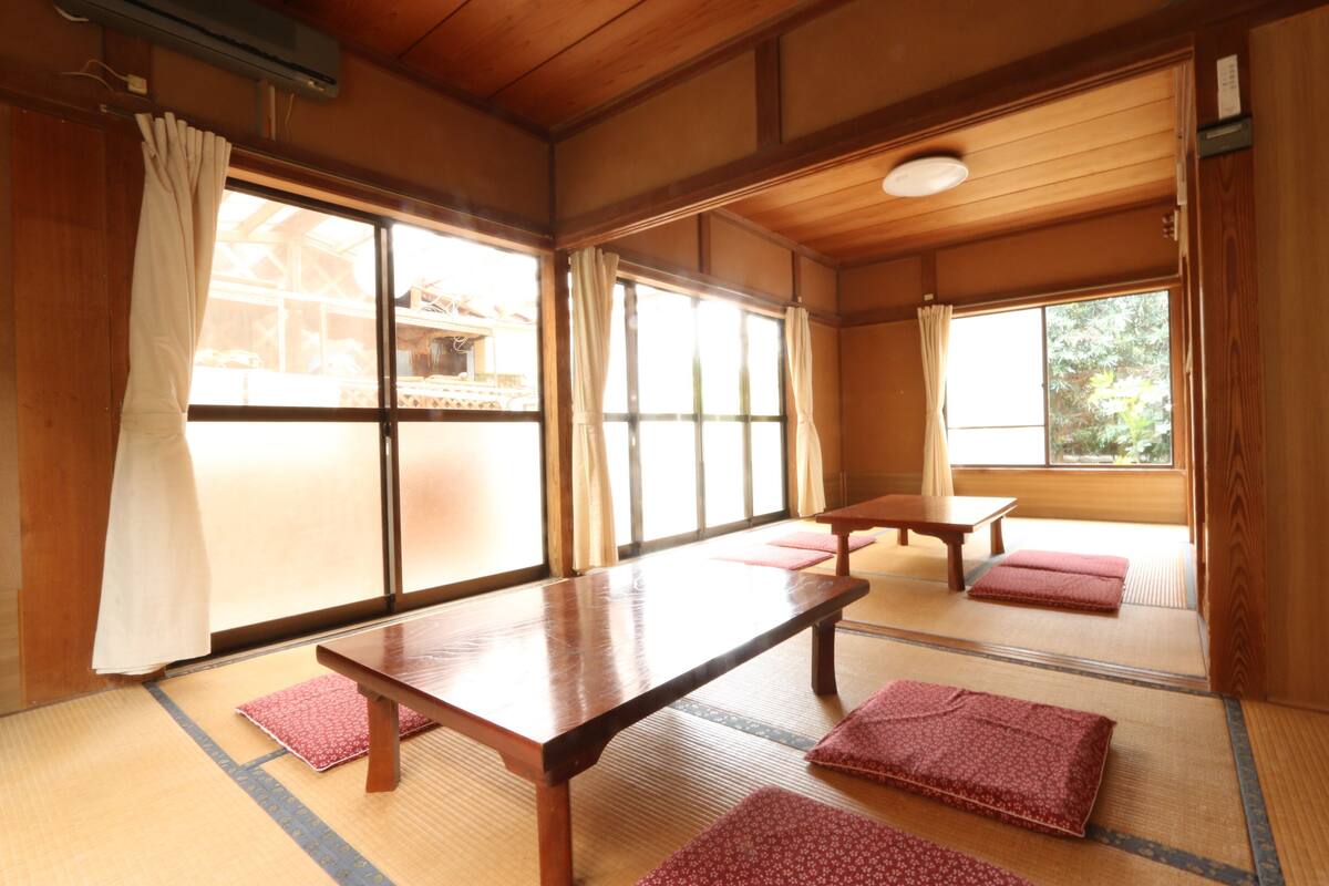Una habitación japonesa tradicional con suelo de tatami, una mesa de madera y puertas correderas.