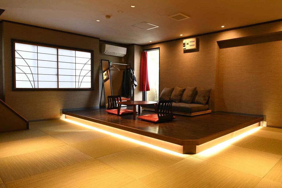 A modern interior with a wooden platform, seating, and a large window.