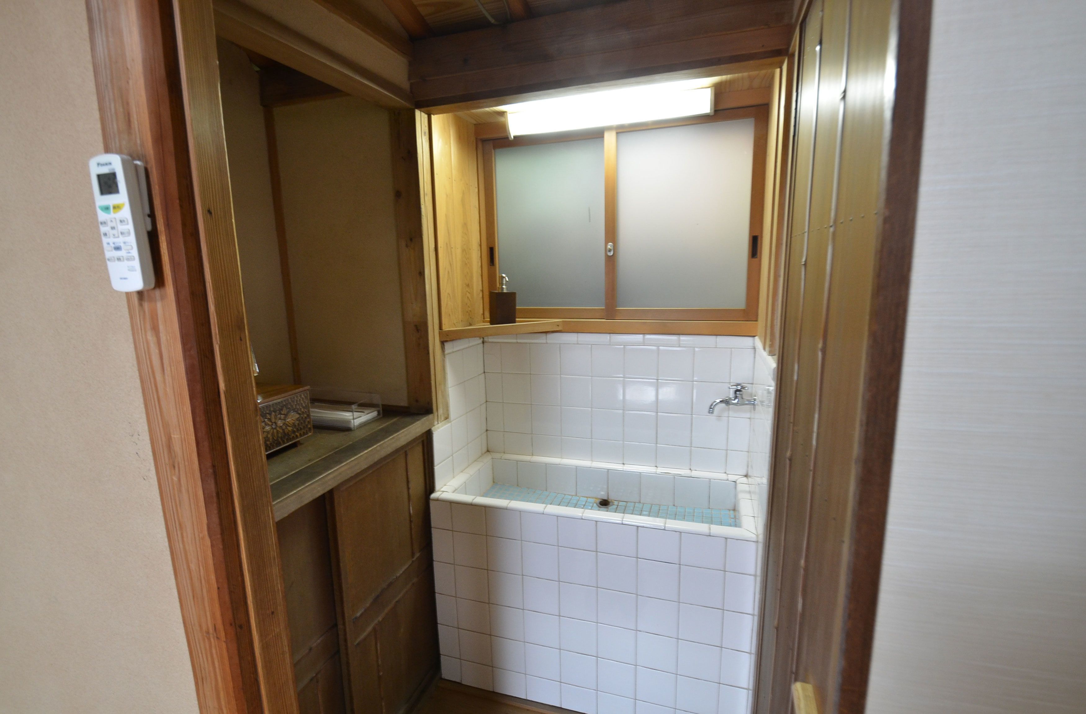Une petite salle de bain comprenant un petit lavabo, un miroir et des toilettes.