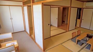 A traditional Japanese room with tatami flooring, sliding doors, and a low table with chairs.