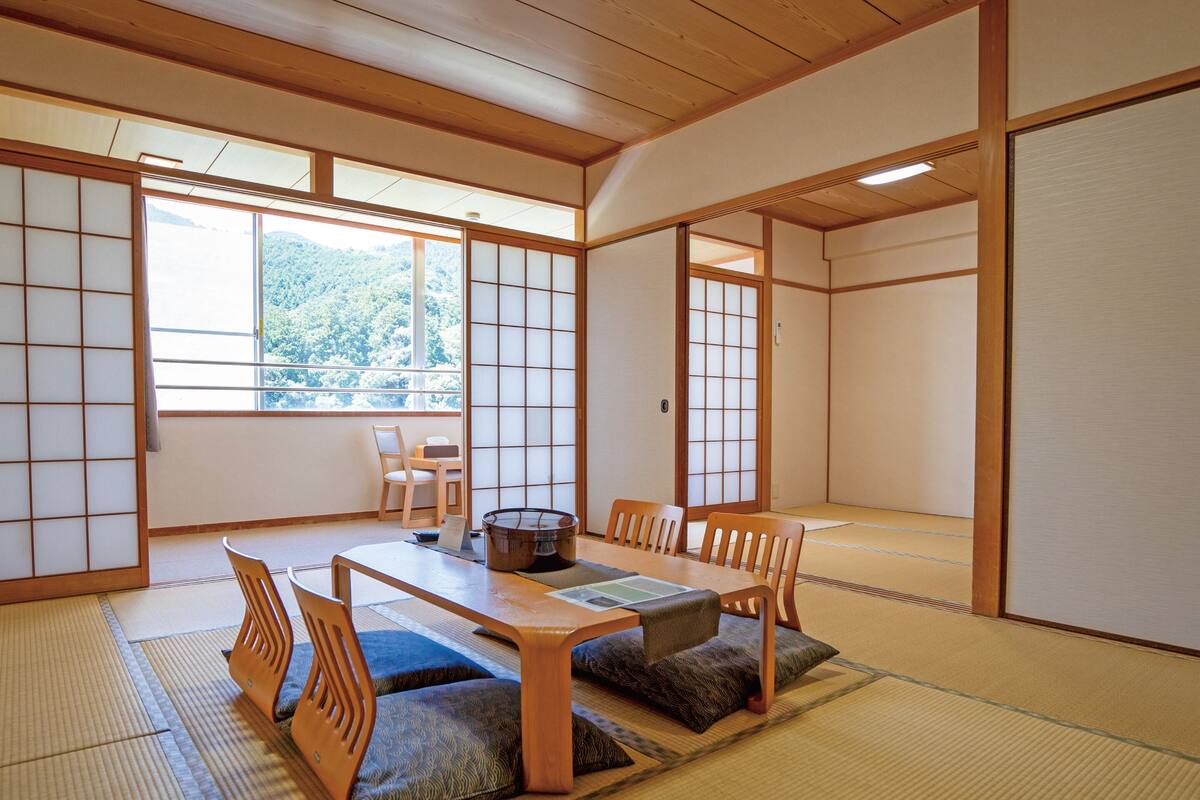 A traditional Japanese room with tatami flooring, a low wooden table, and sliding shoji doors.