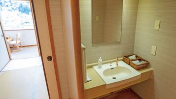 Un baño con lavamanos, espejo y cestas de mimbre en la encimera.