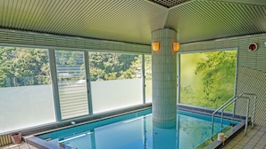 Una piscina con suelo de azulejos y una barrera de cristal.
