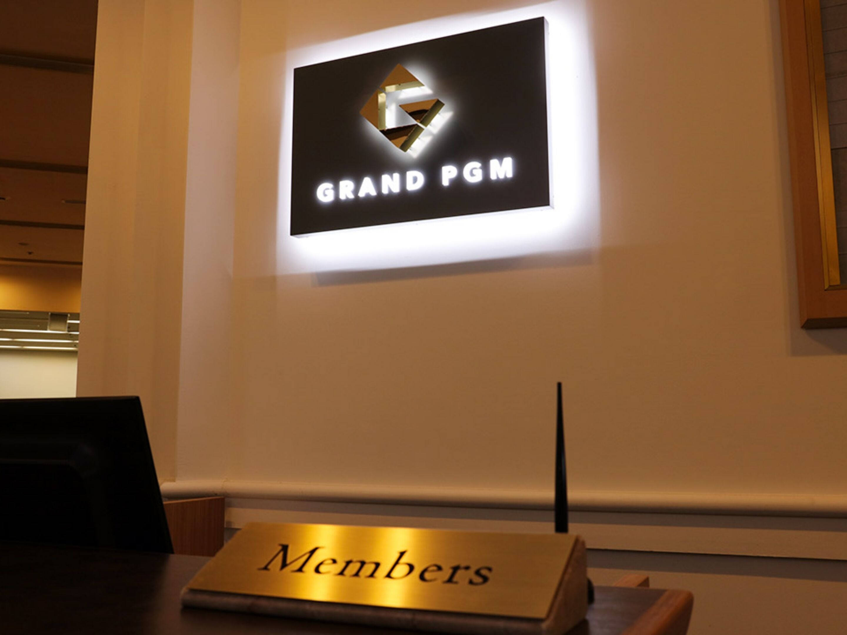 A sign with 'GRAND PGM' and a 'Members' plaque on a table.