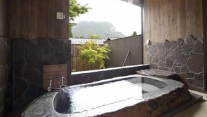 Ein modernes Badezimmer mit einem Steinsink und Bergblick durch ein großes Fenster.