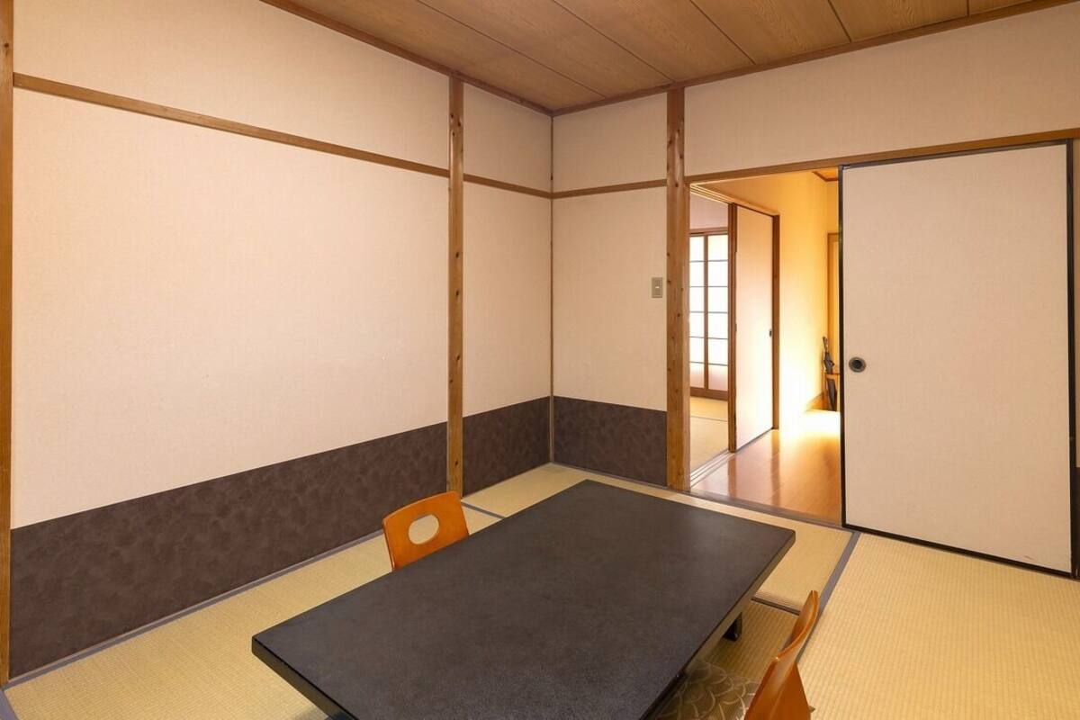A traditional Japanese room with tatami flooring, a low table, and sliding doors.