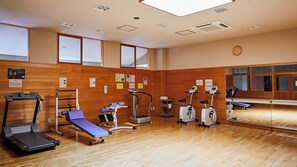 A gym with exercise equipment, wooden walls, and a large mirror. - Hosenbo Lodge (Seiyo)