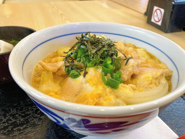 En skål med ramen, garnerad med salladslök och sjögräs.