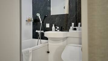 Un baño moderno con bañera, lavamanos e inodoro.