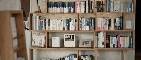 Une bibliothèque remplie de livres et quelques objets encadrés.