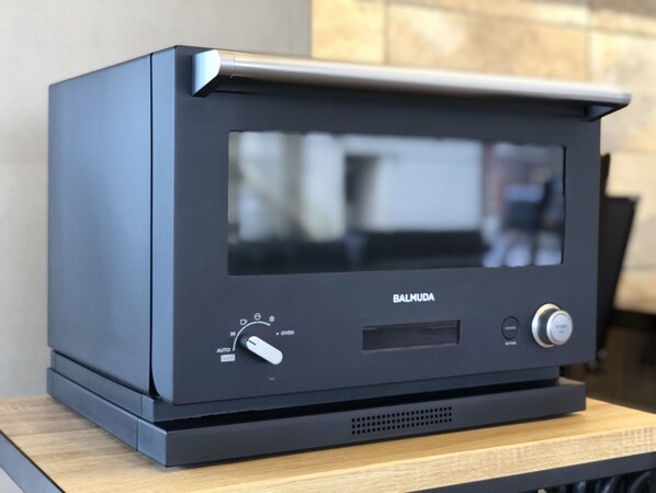 A black Balmuda oven with a control panel, placed on a wooden surface. - Hotel Sunroad (Amakusa)