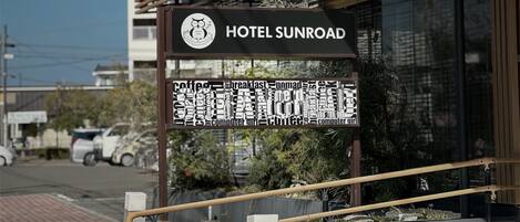 A hotel sign with a logo and the name 'HOTEL SUNROAD'.