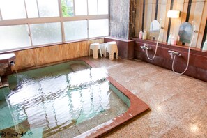 Un baño con una piscina pequeña, ducha y ventana.