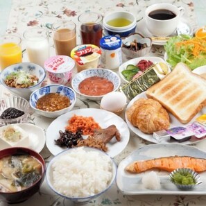 Une table garnie de divers plats, notamment du riz, de la viande et des légumes, ainsi que des boissons et des condiments.