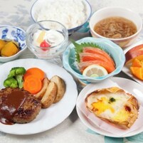Variedad de platos que incluyen un bistec, verduras y un producto horneado, sugiriendo una comida.