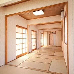 Une pièce de style japonais traditionnel, avec un sol recouvert de tatamis, des portes coulissantes et un luminaire au plafond.