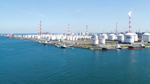 Een industrieel gebied aan de kust, met opslagreservoirs en een kade.