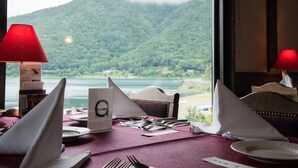 Ein Tisch für zwei Personen mit Blick auf einen See und Wald.