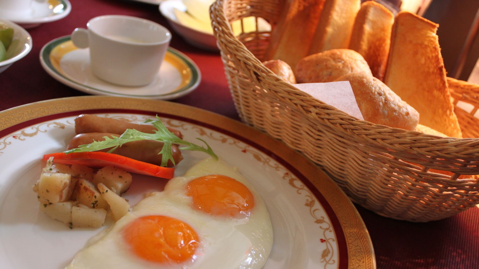 A breakfast setting with a plate of eggs, vegetables, and bread.