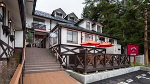 Ein Gebäude mit einer Treppe, die zu einer Terrasse mit Sitzgelegenheiten im Freien führt.