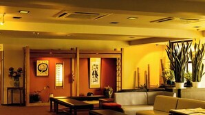 Une pièce de style japonais traditionnel, avec un sol recouvert de tatamis, une table basse, un canapé et un banc.