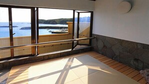 A balcony with a view of the sea and boats, a wooden floor, and a stone wall. - Uehisa (Toba)