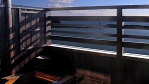A balcony with a view of the sea, a wooden table, and a small bench. - Uehisa (Toba)