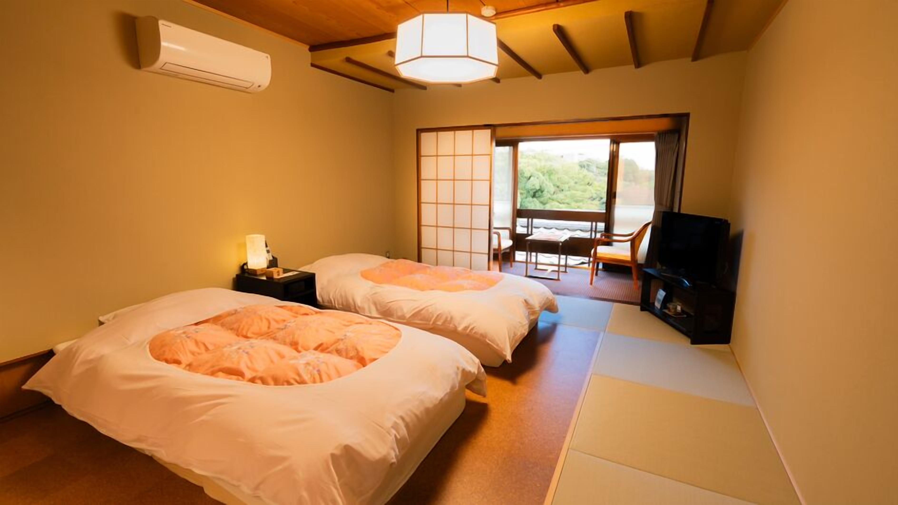 A room with two beds, a TV, and a sliding door to a balcony.