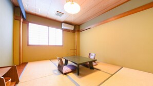 A tatami mat room with a low table and chairs, a window with blinds, and a ceiling vent. - Marue Honkan (Hitoyoshi)