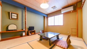 A traditional Japanese room with tatami flooring, a low table, a television, and a window with shoji screens. - Marue Honkan (Hitoyoshi)