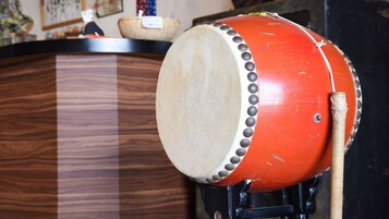 Un tambor de cuerpo rojo y parche blanco, sobre un soporte.