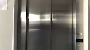 En moderne elevator med metalfinish og digital skærm.
