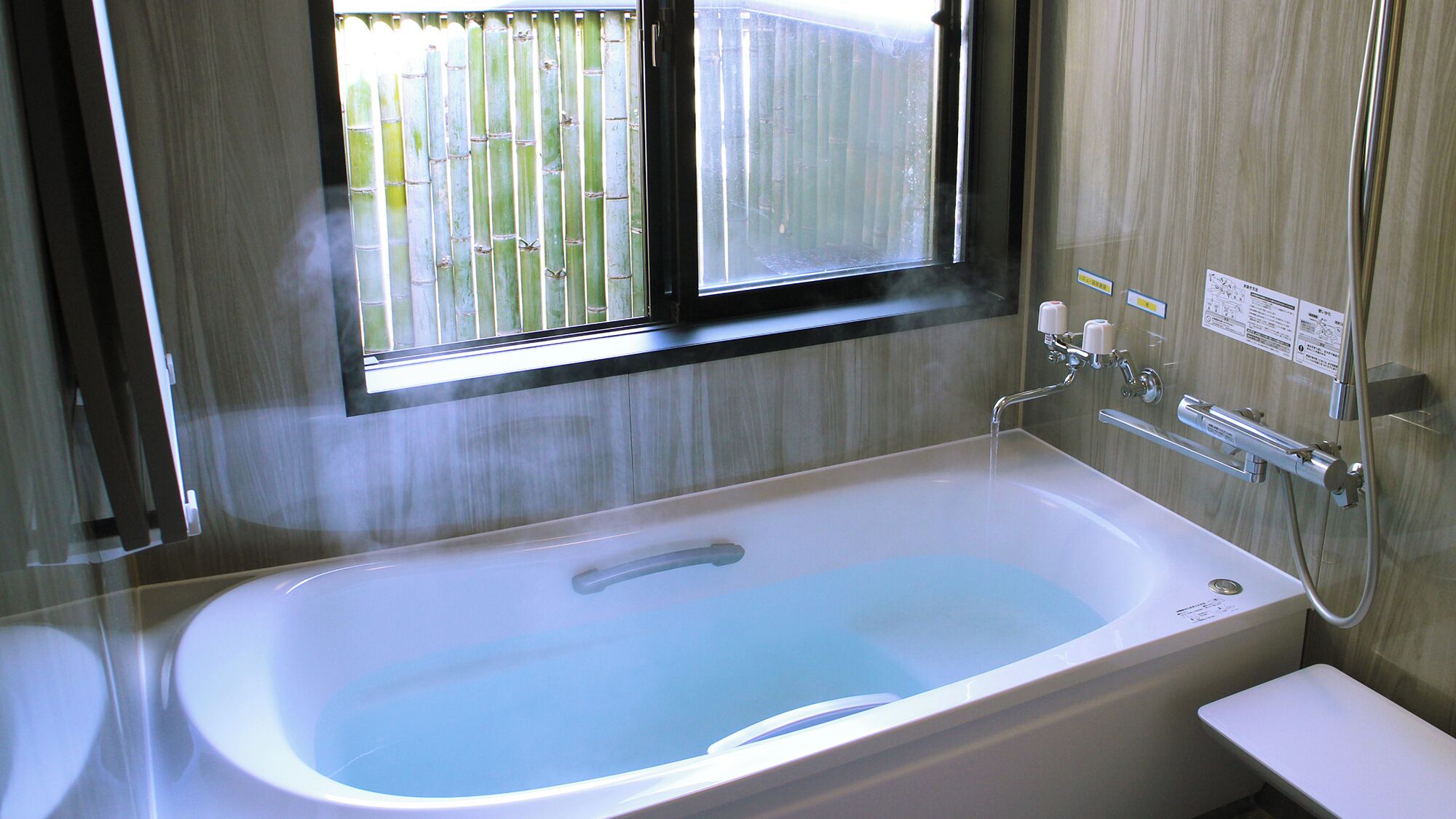 A bathroom with a bathtub, a window, and a shower.