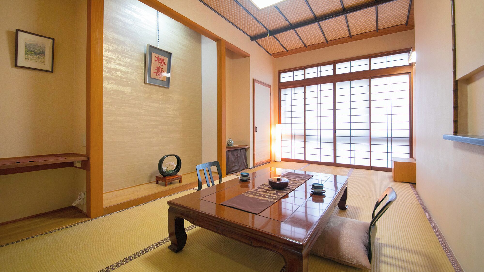 A traditional Japanese room with tatami flooring, a low wooden table, a sliding door, and a large window with shoji screens.
