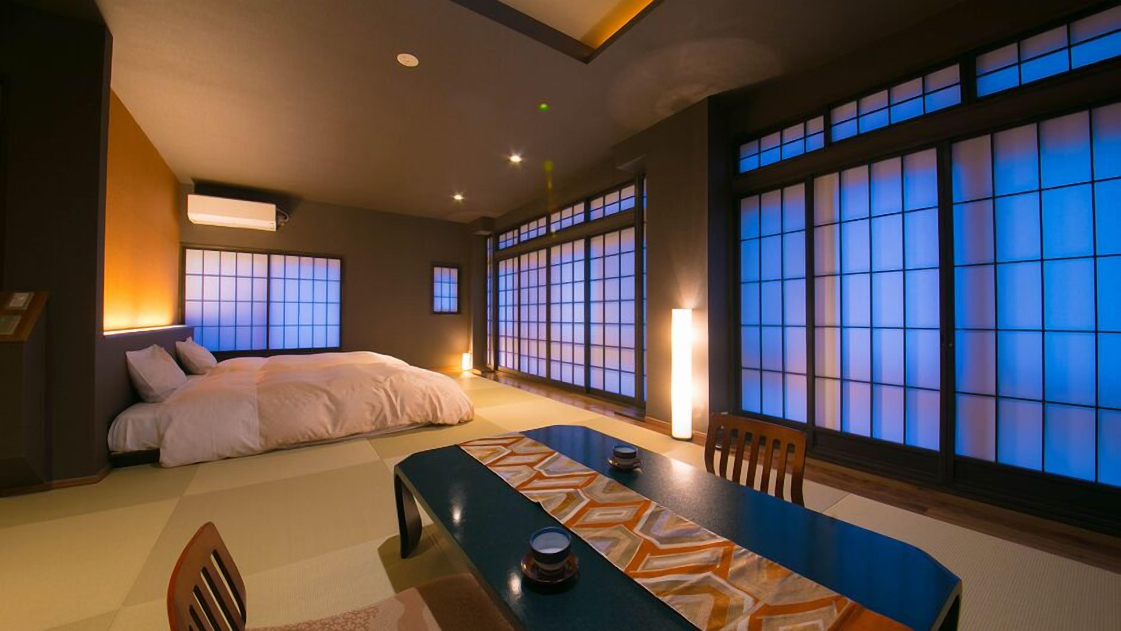 A traditional Japanese-style room with tatami flooring, a low table with cushions, and sliding shoji doors.